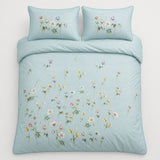 Overhead flat lay of Serenity duck egg floral duvet cover set with two pillows