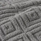 Macro close-up of the grey Romo microfibre fleece fabric with raised diamond pattern