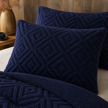 Close-up of navy Romo fleece pillowcases showing the raised geometric sherpa texture