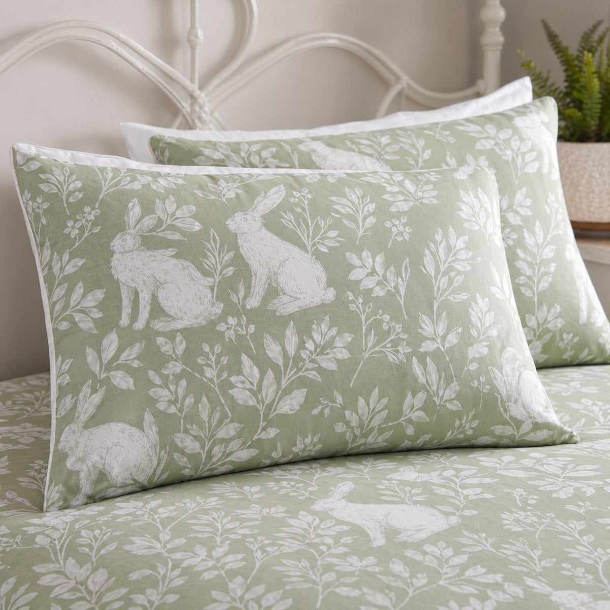 Close-up of Spring Rabbits green pillowcases showing white rabbit and floral silhouette print