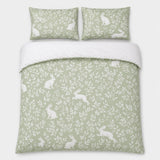 Overhead flat lay of the Spring Rabbits green reversible duvet cover set with two pillows
